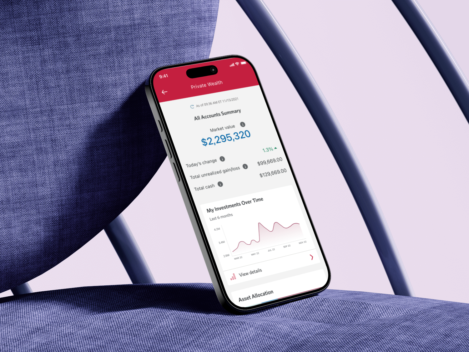 Smartphone displaying a financial app interface showing an account balance of $2,295,320 with investment performance chart and account summary details, positioned on a blue and white geometric background